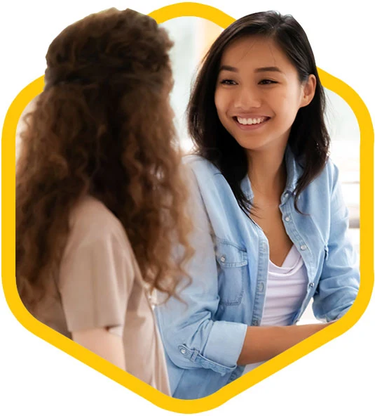 Two female coworkers talking.